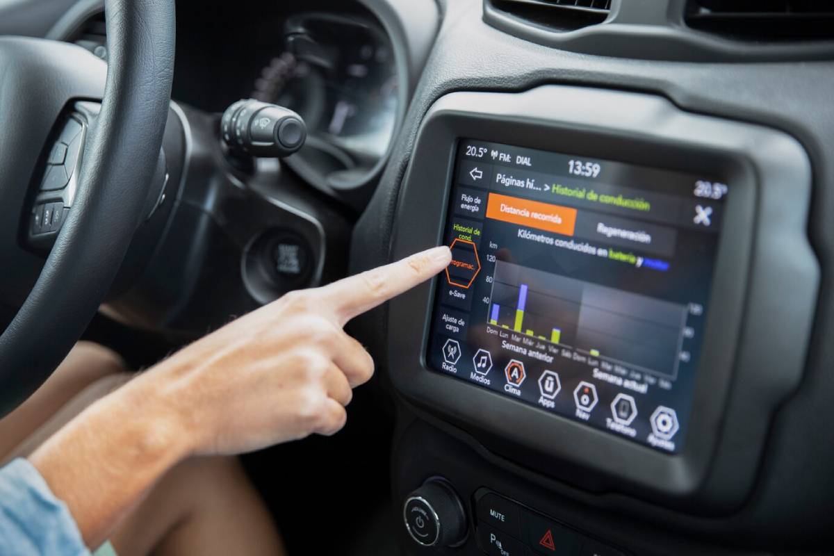 Person using the touchscreen display in a car to interact with vehicle settings and analytics.