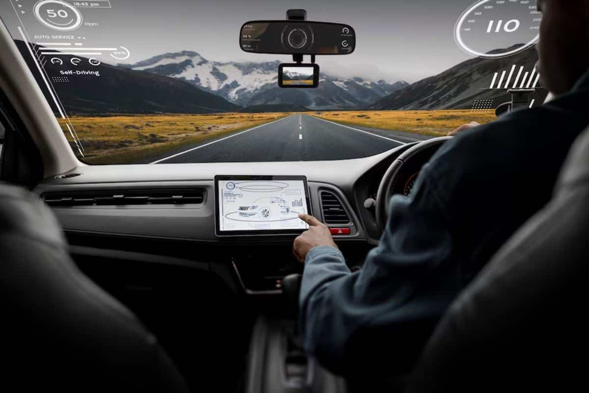 Interior view of a self-driving car with a driver interacting with a touchscreen